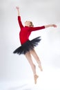 Young woman ballet dancer leaping in a black tutu
