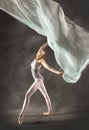 Young woman dancing with green fabric flying in the studio Royalty Free Stock Photo