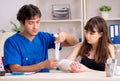 Young woman with bandaged arm visiting male doctor traumotologis Royalty Free Stock Photo