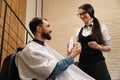 Young woman in a barbershop demonstrates male care products