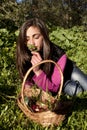 Young woman with basket of eggs picking flowers Royalty Free Stock Photo