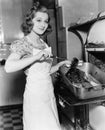 Young woman basting a goose in the kitchen