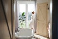 A young woman with bath robe standing in a bathroom by a window in the morning. Royalty Free Stock Photo