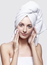 Young woman with bath towel on the head and cosmetic pad in hand Royalty Free Stock Photo