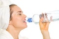 Woman in bathrobe drinking from bottle with water Royalty Free Stock Photo