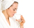Young woman in bathrobe drinking pure water Royalty Free Stock Photo