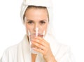 Young woman in bathrobe drinking pure water Royalty Free Stock Photo