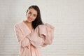 Young woman in bathrobe drying hair with towel near brick wall Royalty Free Stock Photo