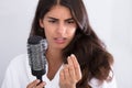 Woman In Bathrobe Holding Comb Looking At Hair Loss Royalty Free Stock Photo