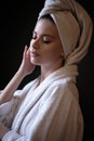 Young woman in a bathrobe and towel on her head, spa and care portrait, clean face Royalty Free Stock Photo