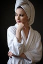 Young woman in a bathrobe and towel on her head, spa and care portrait, clean face Royalty Free Stock Photo