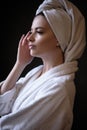 Young woman in a bathrobe and towel on her head, spa and care portrait, clean face Royalty Free Stock Photo