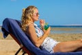 Young woman on beach bed drinking cocktail Royalty Free Stock Photo