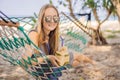 Young woman on the beach in a hammock with a drink Royalty Free Stock Photo