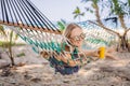 Young woman on the beach in a hammock with a drink Royalty Free Stock Photo