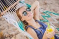 Young woman on the beach in a hammock with a drink Royalty Free Stock Photo