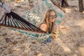 Young woman on the beach in a hammock with a drink Royalty Free Stock Photo