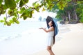 Young woman on beach holding umbrella checking for rain