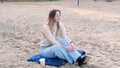 Young woman on the beach in jeans and a sweater. stress-free concept. Slow living. Enjoying the little things. Lykke