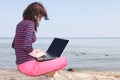 Young woman on the beach with a laptop Royalty Free Stock Photo