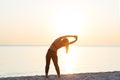 Young woman at the beach stretching after workout Royalty Free Stock Photo