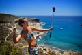 Young woman on the beach in summer using gopro