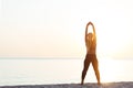 Young woman at the beach stretching after workout Royalty Free Stock Photo