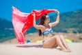 Young woman with beach towel during tropical vacation. Beautiful girl enjoy her summer holidays. Royalty Free Stock Photo
