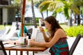 Young woman, eating desert in a restaurant on beach summer resort Royalty Free Stock Photo