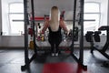 Young woman with a beautiful body is doing hand exercises in a modern gym. Girl goes in for sports indoors. Royalty Free Stock Photo