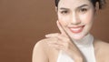 Young woman with beautiful face smiling , touching her face over brown background , beauty skin care concept Royalty Free Stock Photo