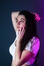 a beautiful young woman touching her head while standing in a room Royalty Free Stock Photo