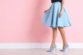 Young woman with beautiful long legs in stylish outfit near color wall, closeup Royalty Free Stock Photo