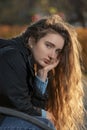 Young woman with beautiful looks into the camera with long chestnut thick curly hair . Girl with auburn wavy hair Royalty Free Stock Photo