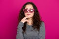 Young woman beautiful portrait, posing on pink background, long curly hair, sunglasses in heart shape, glamour concept Royalty Free Stock Photo