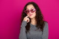 Young woman beautiful portrait, posing on pink background, long curly hair, sunglasses in heart shape, glamour concept Royalty Free Stock Photo