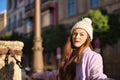 Young woman, beautiful, straight brown hair, sweater, coat and wool hat, supported by a large chain, with a sensual and