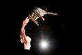 Young woman beautifully jumps in the air at night