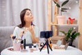 Young woman beauty blogger recording live video tutorial make up for social network vlog, highlighter apply brush to Royalty Free Stock Photo