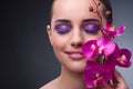 The young woman in beauty concept with orchid flower Royalty Free Stock Photo