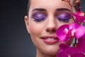 The young woman in beauty concept with orchid flower Royalty Free Stock Photo