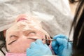 Young woman in beauty salon does manual face cleaning