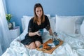 Young woman in bed eating breakfast Royalty Free Stock Photo