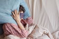 young woman in bed wakes up, insomnia, sleep disorder. person in sleep mask holds onto pillows Royalty Free Stock Photo