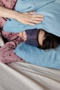 young woman in bed wakes up, insomnia, sleep disorder. person in sleep mask holds onto pillows Royalty Free Stock Photo