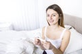 Young woman in bedroom at home wearing in white check pregnant test Royalty Free Stock Photo