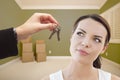 Young Woman Being Handed Keys in Empty Room with Boxes Royalty Free Stock Photo