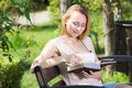 Young woman on bench reading book Royalty Free Stock Photo