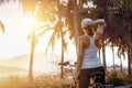 Young woman with bicycle on the coast watches a beautiful sunset on a summer day. Sport and relax.