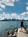 Young woman with bicycle enjoying cityscape view on Toronto city in Canada. Sport summer activity in modern large town. Canadian